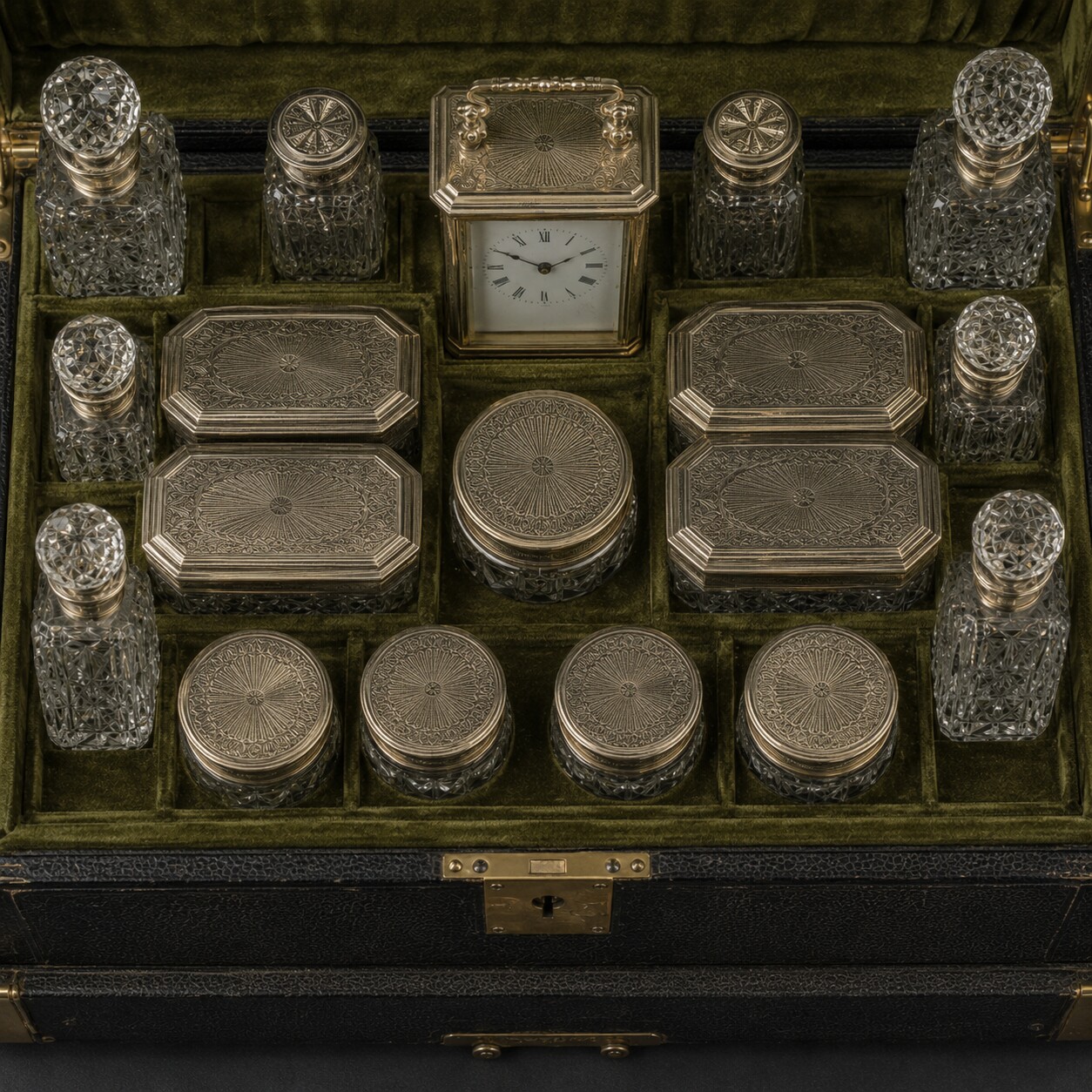 Overhead editorial reconstruction of cut-glass bottles, oblong boxes and circular boxes with coordinated silver-gilt covers in olive velvet fittings.