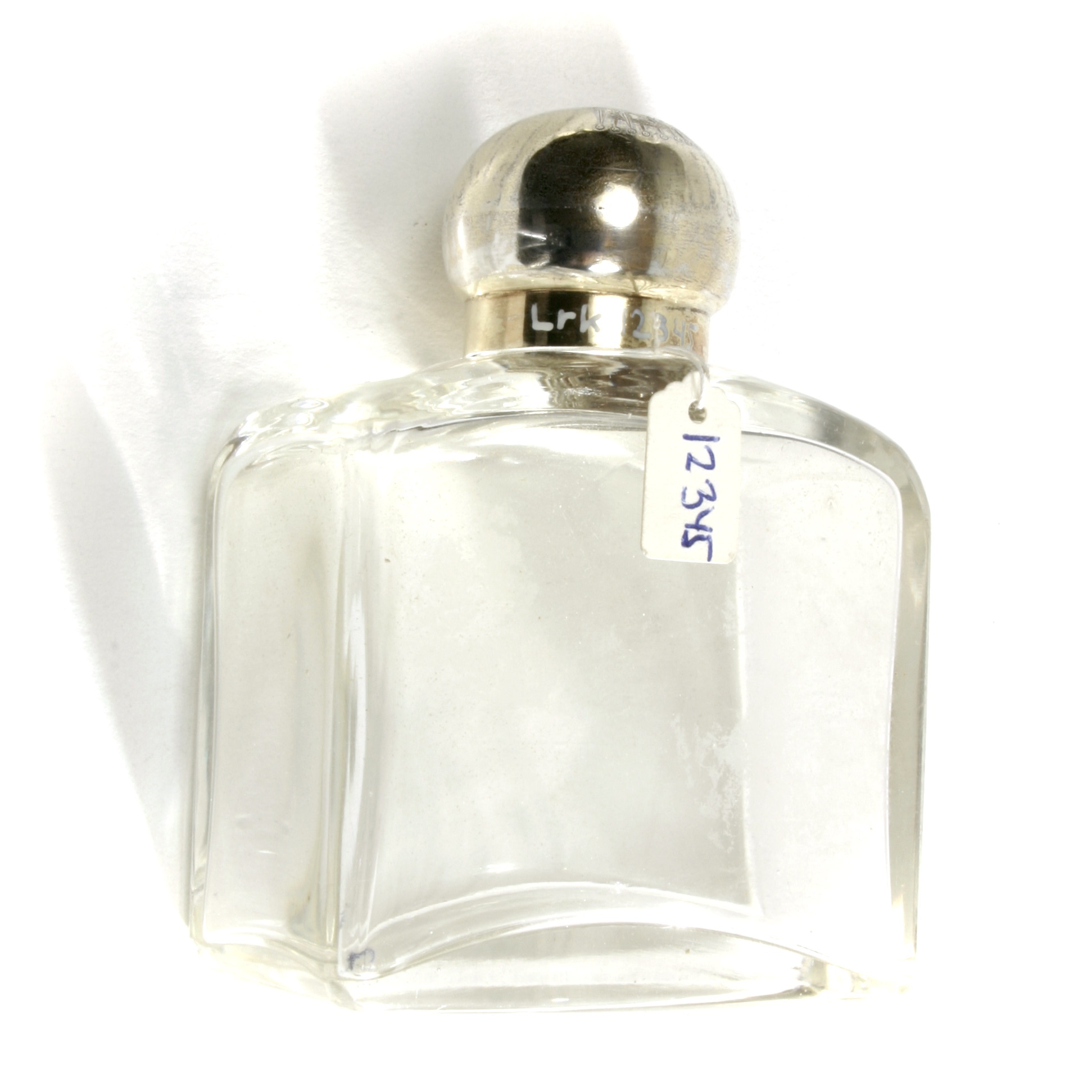 Thick rectangular glass bottle with threaded neck, spherical silver-gilt cover and crowned monogram.